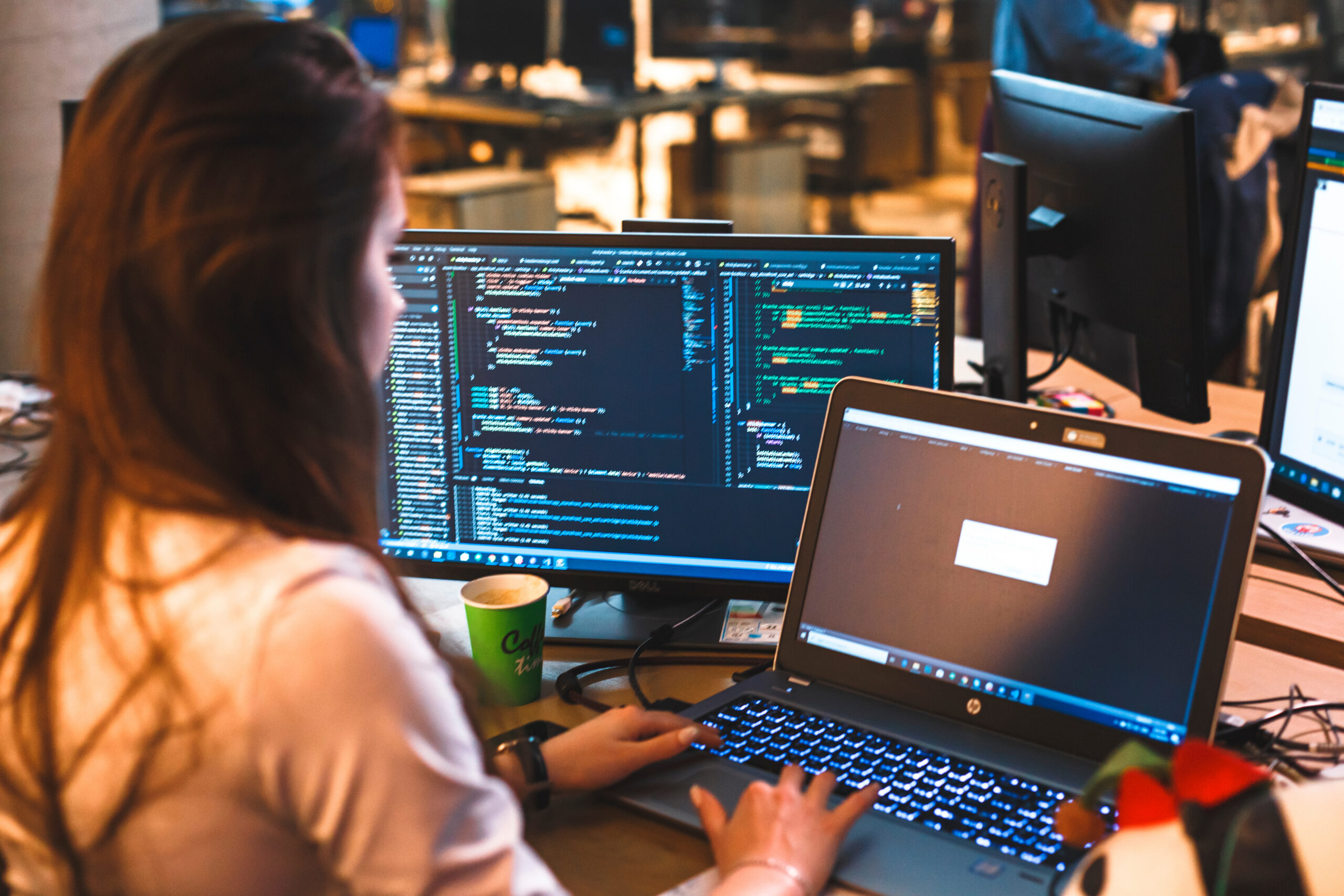 A woman working on computers at a desk.